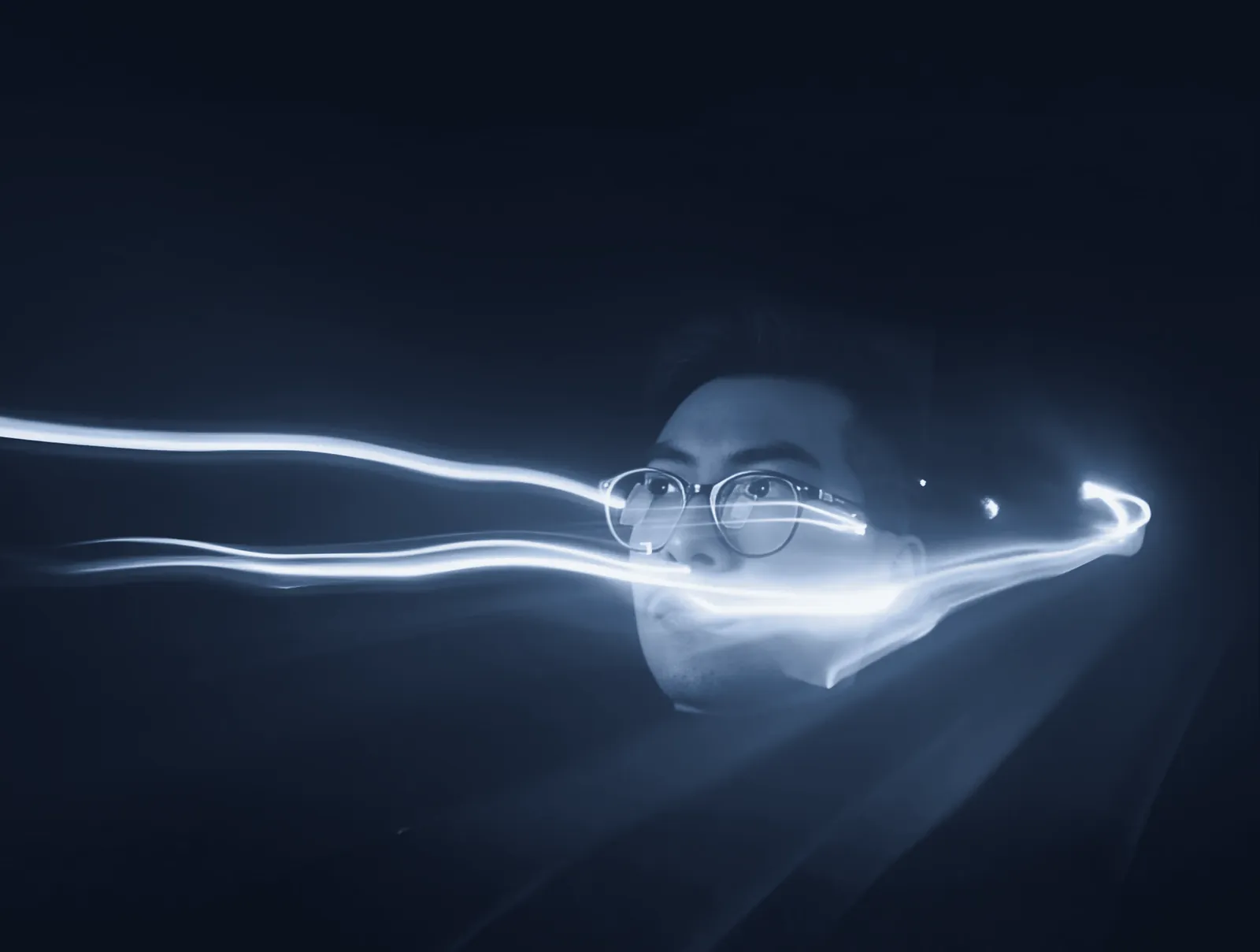 Andrés in the dark, crossed by trails of white light.